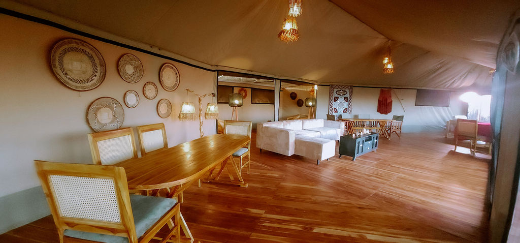 The dining pavilion with woven baskets and a long candlelit table