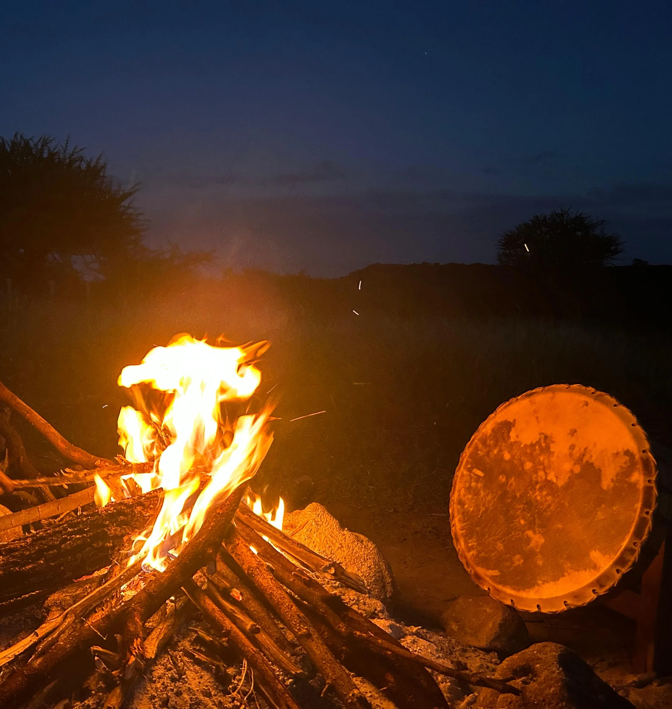 A fire and traditional drum at dusk at the retreat