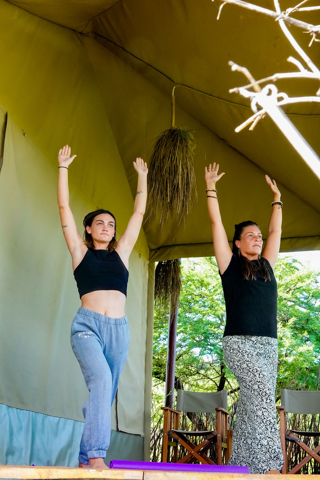 Two women in tree pose on the yoga deck